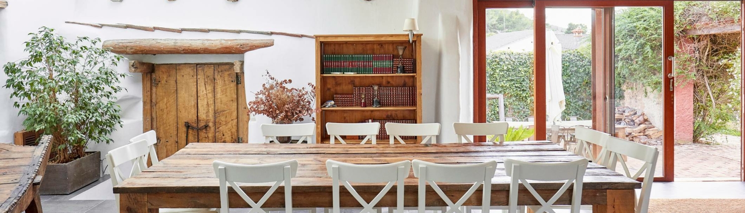 wood dining table with white chairs and wood accents in the room